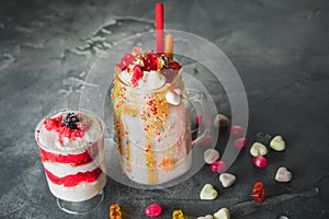 Pink unicorn milkshake with whipped cream and sweet dessert, dripping sauce and sugar candy
