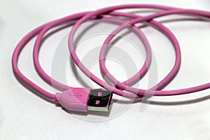 Pink used USB plug with cable on the white background.