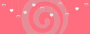Pink valentine`s day background with hanging white hearts