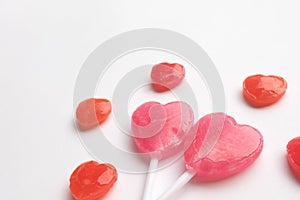 Pink Valentine`s day heart shape lollipop with small red candy in cute pattern on empty white paper background. Love Concept. Min