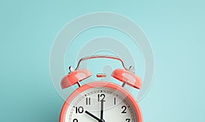 Pink vintage alarm clock on green color background