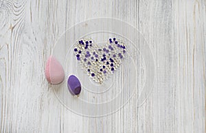 Pink and violet beauty blenders, sponges on wooden grey background. Cosmetic tools for makeup and hydrogel balls in the form of he