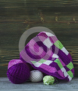 Pink, violet, magenta, white and green plaid and balls. Cotton yarn for knitting, crochet. The beginning of bright plaid, checkere