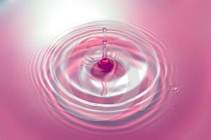 Pink water drop and waves around