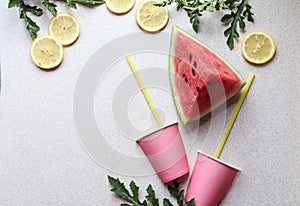 Pink watermelon slice, juice glasses with straws, lemon slices, top view, place for text-the concept of making fresh healthy