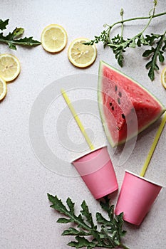 Pink watermelon slice, juice glasses with straws, lemon slices, top view, vertical frame-the concept of making fresh healthy