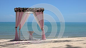 Pink Wedding Arch on Sandy Beach Beside the Sea
