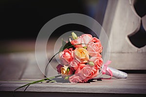 Pink wedding bouquet of roses on a bench in a rich house, gentle warm tinting