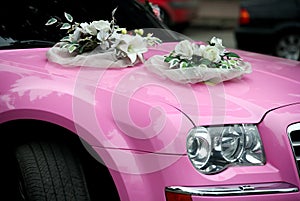 Pink wedding car with a bouquet of flowers