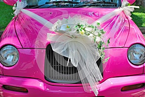 Pink wedding car with bouquet of flowers