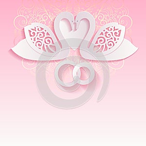 Pink wedding card with swans and intertwined wedding rings.