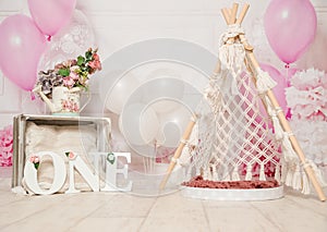 pink and white decoration for a 1st birthday cake smash studio photo shoot with balloons, paper decor, cake and topper