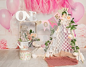 pink and white decoration for a 1st birthday cake smash studio photo shoot with balloons, paper decor, cake and topper