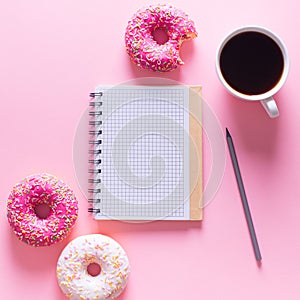 Pink and white donuts with cup of coffee and note on pink backgr