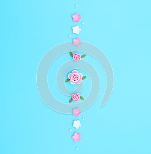 Pink and white flowers made of foamiran with green leaves and white beads on blue background. Mother day, Valentine day, Wedding,