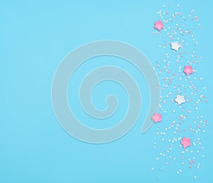 Pink and white flowers made of foamiran with star shaped confetti on blue background. Mother day, Valentine day, Wedding, Birthday