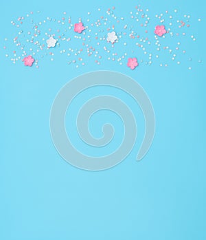 Pink and white flowers made of foamiran with star shaped confetti on blue background. Mother day, Valentine day, Wedding, Birthday