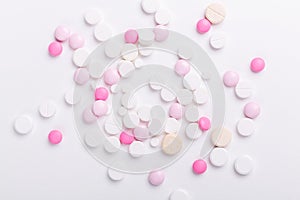 Pink and white pills on white background. Heap of assorted various medicine tablets and pills. Health care