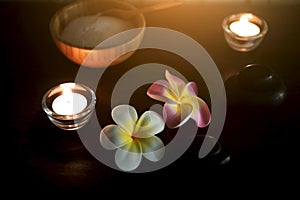 Pink and white Plumeria flowers with rock and Salt for exfoliation in wood Coconut cup on weave plate decoration in spa and Candle