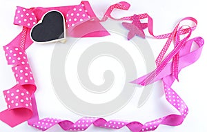 Pink and white polka dot ribbons make a border on a white background.
