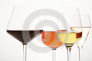 Pink, white, red, sparkling alcoholic drinks in wine glasses.