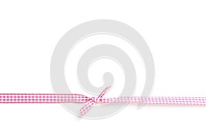 Pink and white rips textile ribbon with bow on white background