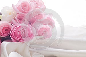 Pink and white roses laying in silk with backlight
