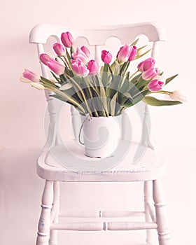 Pink and white tulips on a chair