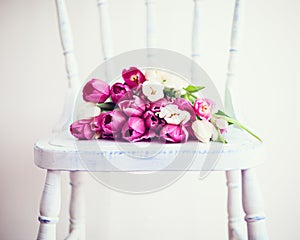 Pink and white tulips on a chair