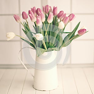Pink and white tulips on a jar