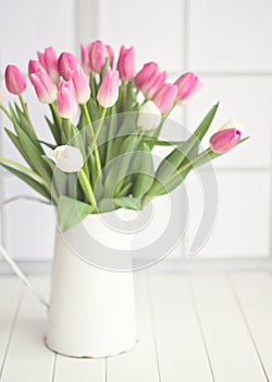 Pink and white tulips on a jar