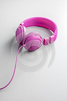 Pink wired stereo headphones on gray background