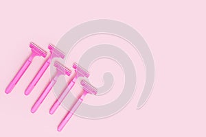 Pink woman shavers isolated on pink paper background. Flat lay with copy space.