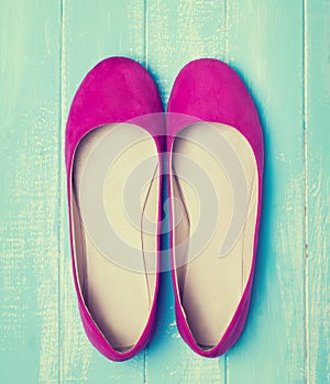 Pink woman shoes on blue colored wooden background