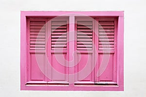 Pink wooden window is classic vintage style on white cement wall