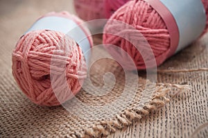 Pink wool balls on wooden table background