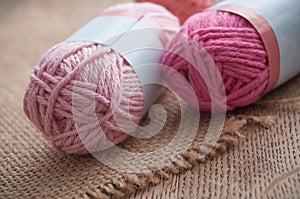 Pink wool balls on wooden table background