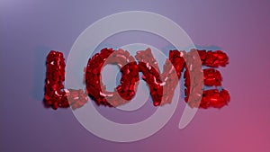 The pink word LOVE explodes into small particles. 3D render animation.