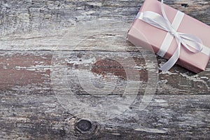 Pink wrapped present on wooden surface in the right corner