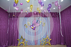 Pink and yellow balloons float on the white ceiling in the room for the party. Wedding or children birthday party decoration