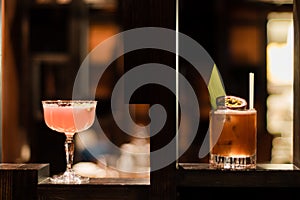 Pink and yellow cocktails garnished with fig and flowers