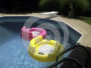 Pink and Yellow Float Tubes in a Backyard Pool