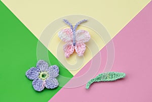 Pink, yellow and green background, crochet butterfly, flower and leaf, spring time