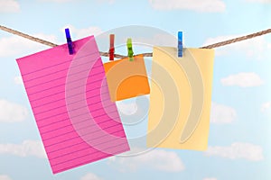 Pink, yellow and orange note paper on clothesline