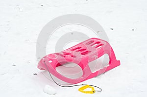 Pink and yellow plastic sleigh on for the children during winter