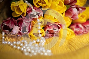 Pink and yellow tulips bouquet lying on a yellow knitted fabric