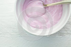 Pink yoghurt with spoon closeup in cup
