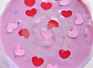 Pink yogurt with little decorative hearts love background