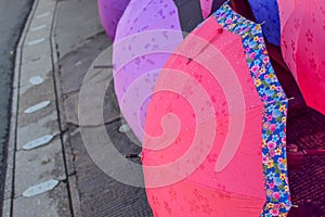 Pinkish umbrellas by the road with water droplets on them