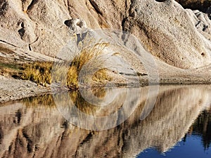 Pinkish-white sandstone cliffs reflecting in the waters of the Blue Lake at St Bathans on the South Island of New Zealand